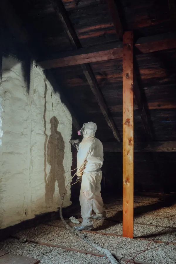 Patriot crew member in protective gear during spray foam install